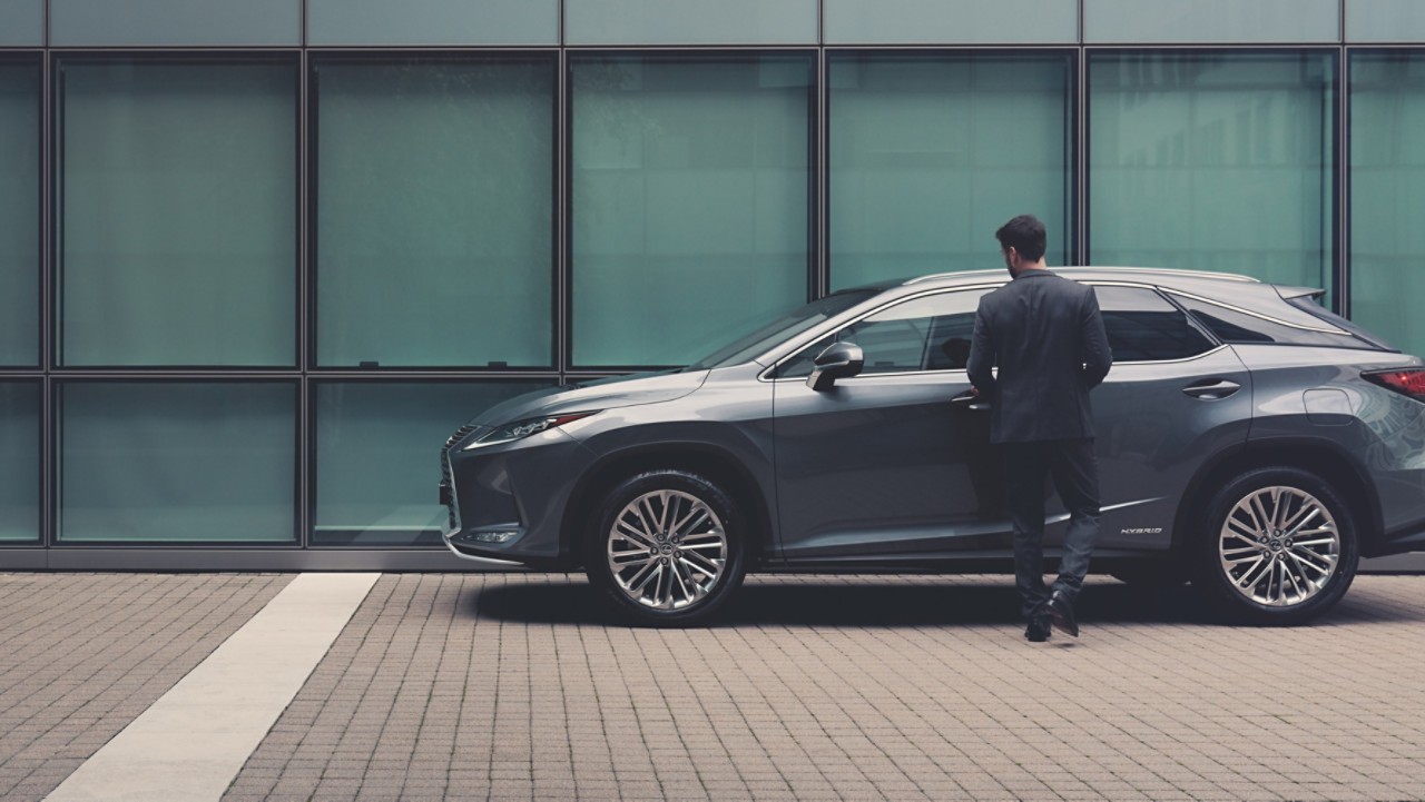 man leaning on a Lexus car