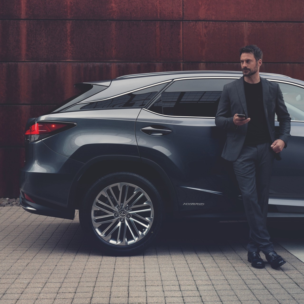 man leaning on a Lexus car