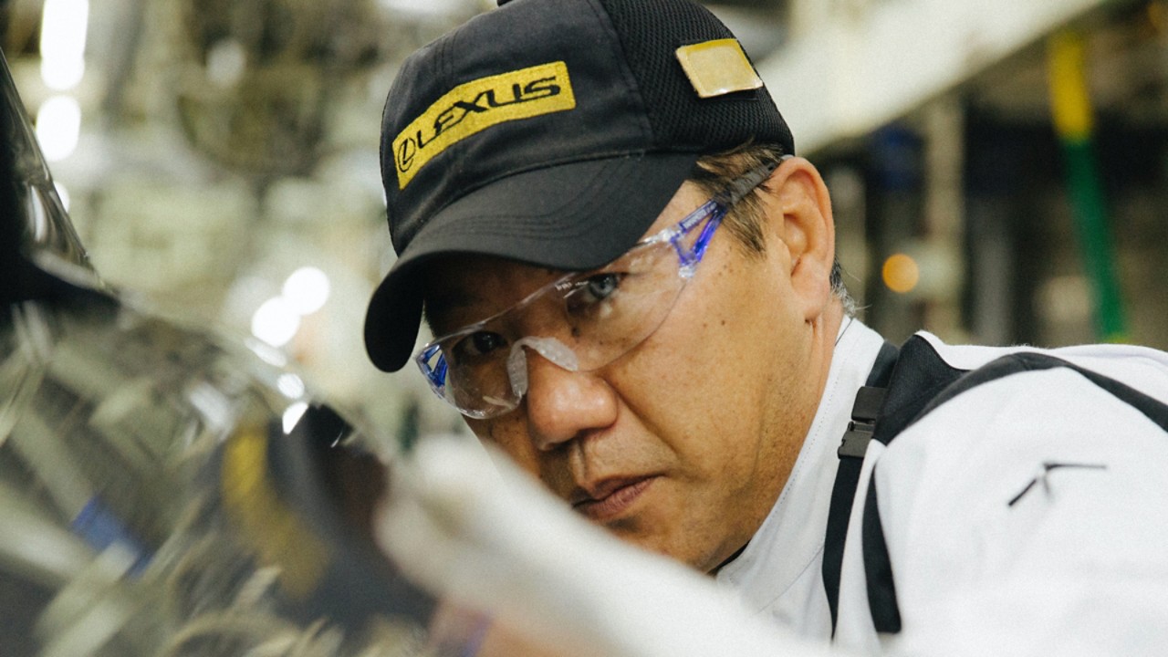 close up of a Lexus worker looking towards a car