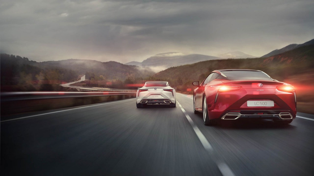 A Lexus 500h and Lexus 500 driving on a road 