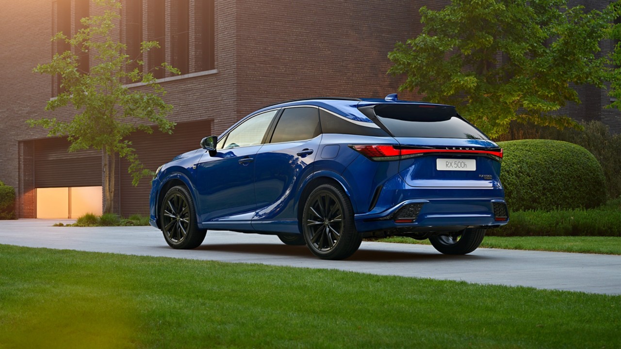 A man walking towards a parked Lexus ES